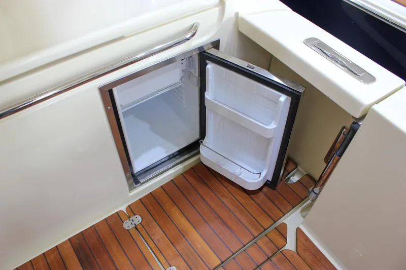 Slide: The Image of Open mini fridge on 2018 Chris-Craft Calypso 30 boat with wooden flooring. - 32