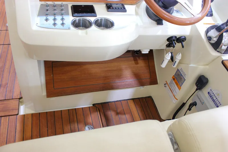 Slide: The Image of 2018 Chris-Craft Calypso 30 helm with wooden accents and control panel. - 46