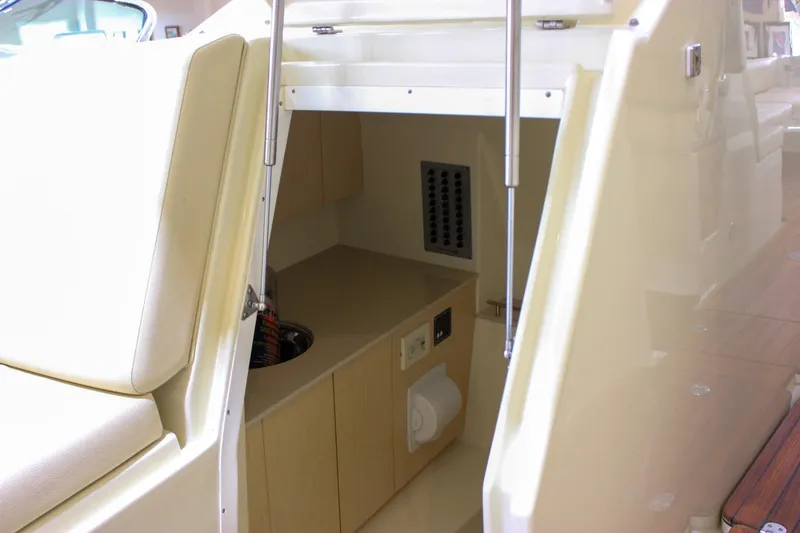 Slide: The Image of 2018 Chris-Craft Calypso 30 interior cabin with seating and storage area. - 59