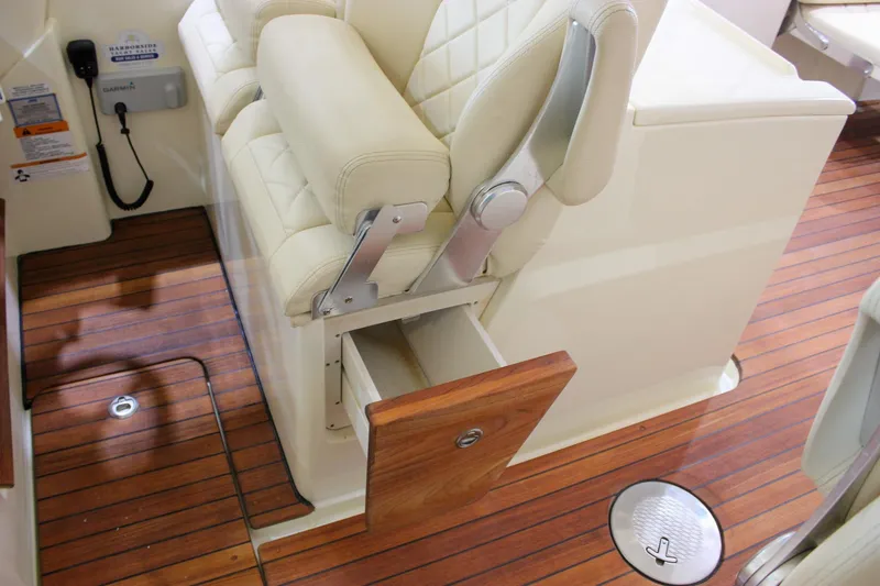 Slide: The Image of 2018 Chris-Craft Calypso 30 interior with beige seating and wooden storage drawer. - 62