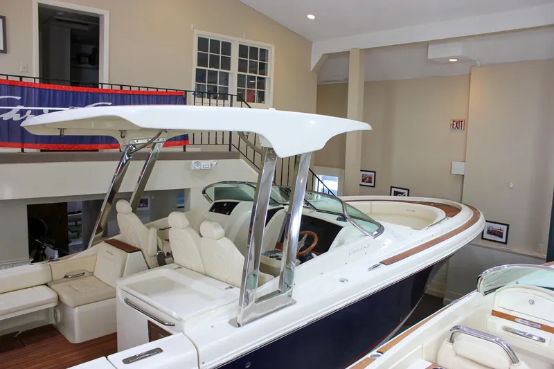 Slide: The Image of 2018 Chris-Craft Calypso 30 boat interior with seating and helm, displayed indoors. - 67