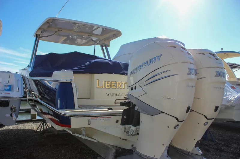 Slide: The Image of 2018 Chris-Craft Calypso 30 boat with twin Mercury 300 engines, docked under clear skies. - 75