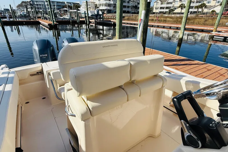 Slide: The Image of 2022 Grady-White Fisherman 257 boat interior at marina, featuring dual engines and helm. - 31
