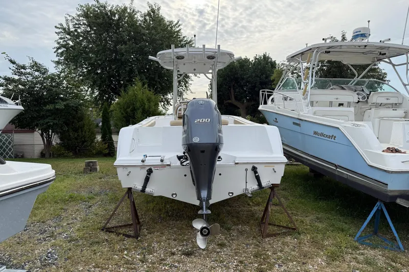Slide: The Image of 2017 Sportsman Open 232 Center Console boat with Yamaha 200 engine, parked outdoors. - 2