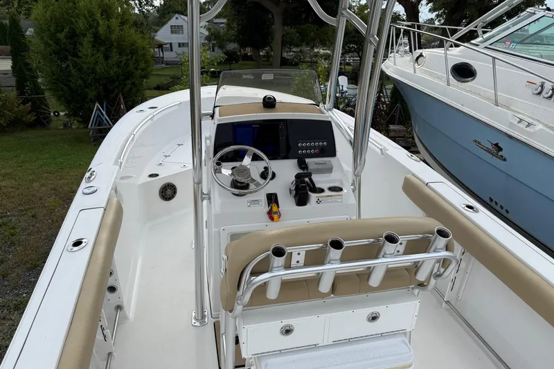 Slide: The Image of 2017 Sportsman Open 232 Center Console boat with beige seating and fishing rod holders. - 5