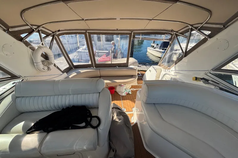 Slide: The Image of Interior of a 2002 Cruisers Yachts boat with white seating and wooden flooring. - 10