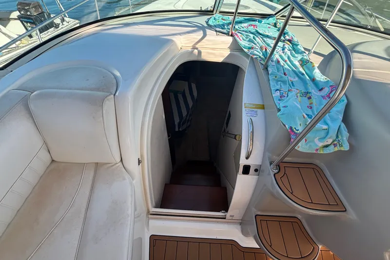 Slide: The Image of 2002 Cruisers Yachts interior with stairs, white seating, and a colorful towel. - 11