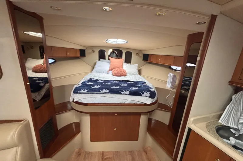 Slide: The Image of Luxurious 2002 Cruisers Yachts cabin interior with cozy bed and elegant wood finishes. - 12