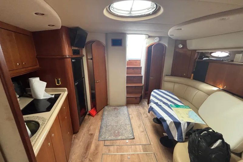 Slide: The Image of Interior of 2002 Cruisers Yachts with kitchenette, seating area, and wooden cabinetry. - 14