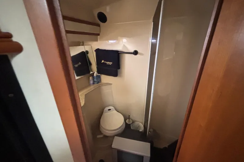 Slide: The Image of Bathroom interior of a 2002 Cruisers Yachts, featuring a toilet and shower. - 16