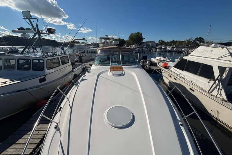 Slide: The Image of 2002 Cruisers Yachts boat docked at marina, surrounded by other vessels under a clear sky. - 24