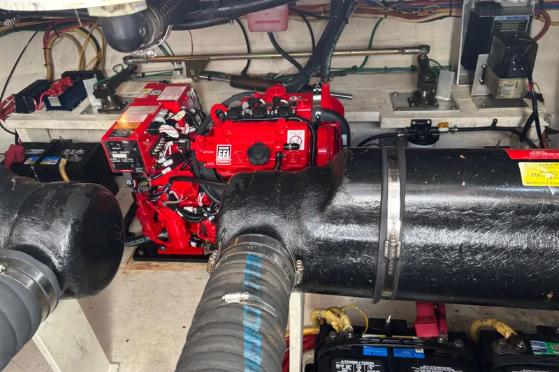 Slide: The Image of Engine room of a 2002 Cruisers Yachts, featuring a red engine and various components. - 25