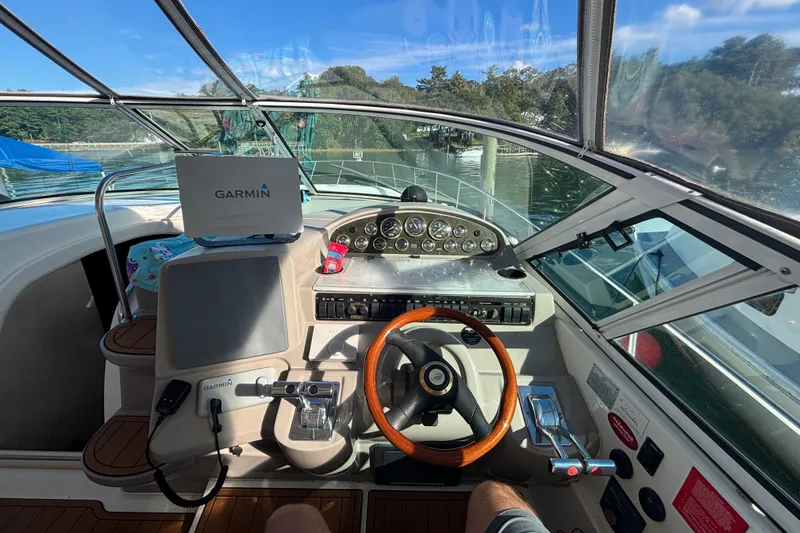 Slide: The Image of 2002 Cruisers Yachts helm with Garmin navigation, wooden steering wheel, and control panel. - 7