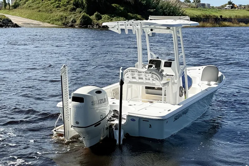 Slide: The Image of 2020 Sea Pro 228 Center Console boat with Suzuki engine on a calm river. - 2