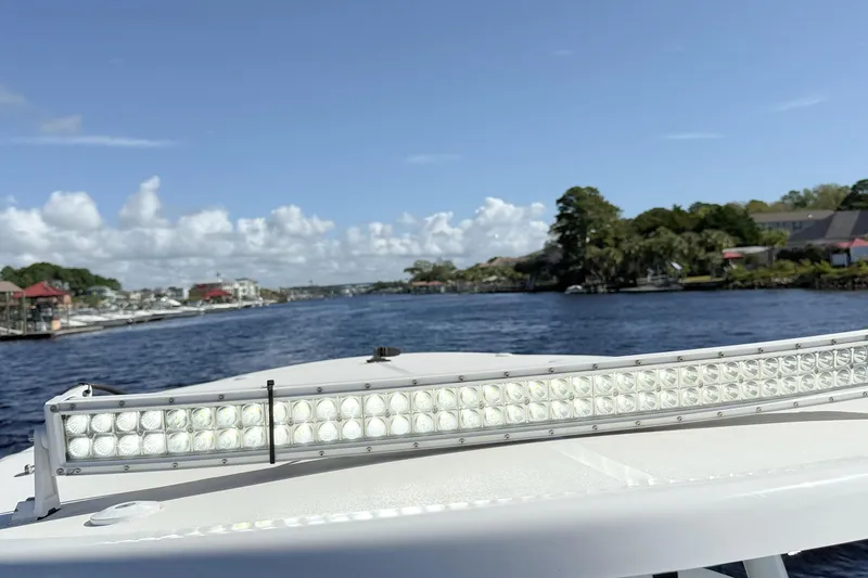 Slide: The Image of 2020 Sea Pro 228 Center Console boat on water, featuring LED light bar, scenic background. - 21