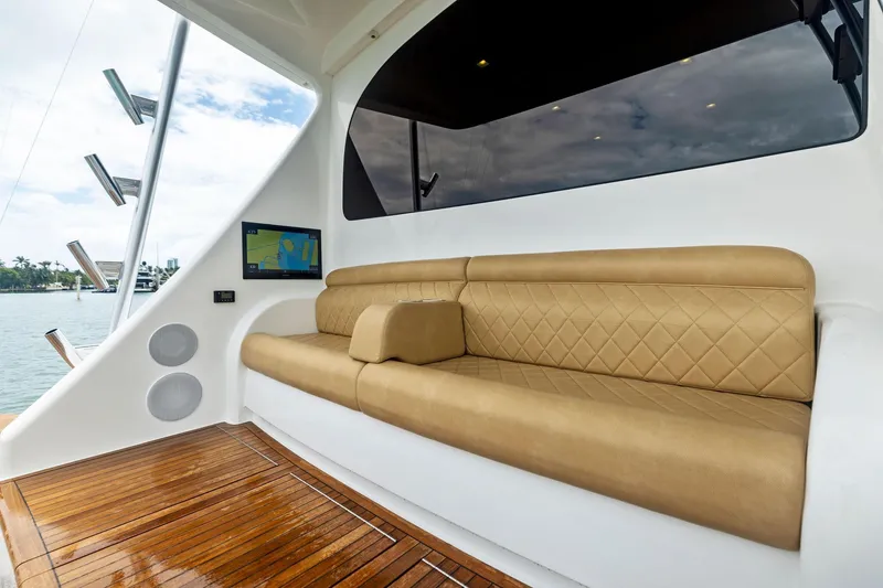 Slide: The Image of Luxurious seating area on 2018 Viking 80 Convertible yacht with tan upholstery and wood flooring. - 8