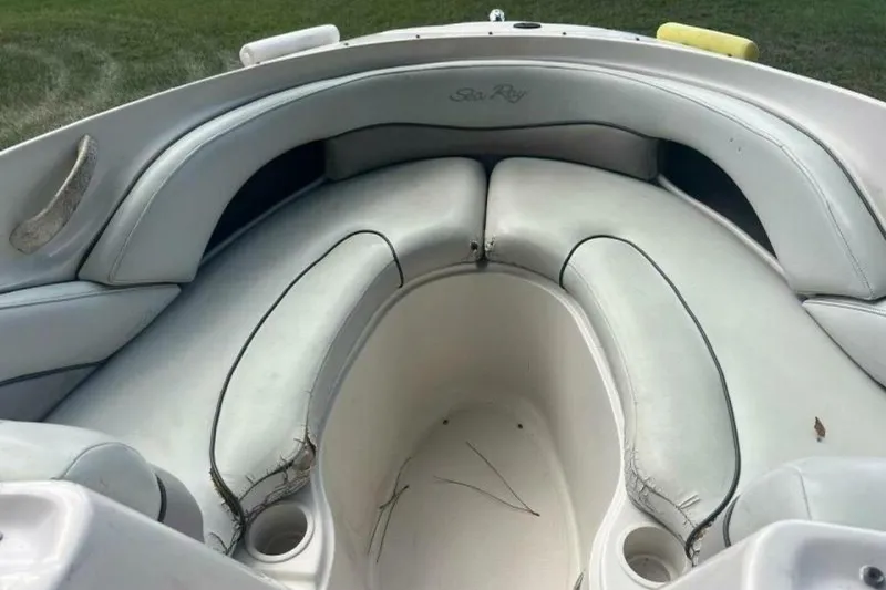 Slide: The Image of 2003 Sea Ray 220 Bow Rider interior with white seating and cup holders. - 16