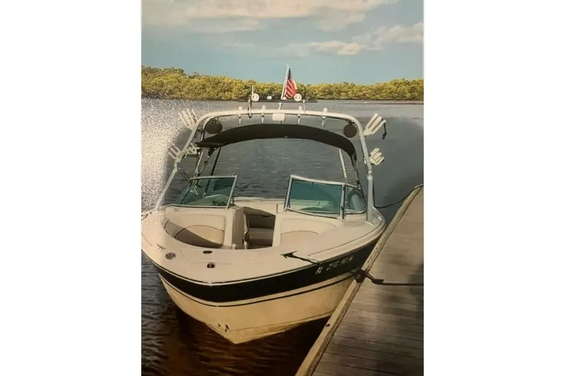 Slide: The Image of 2003 Sea Ray 220 Bow Rider docked on a calm lake with scenic background. - 28
