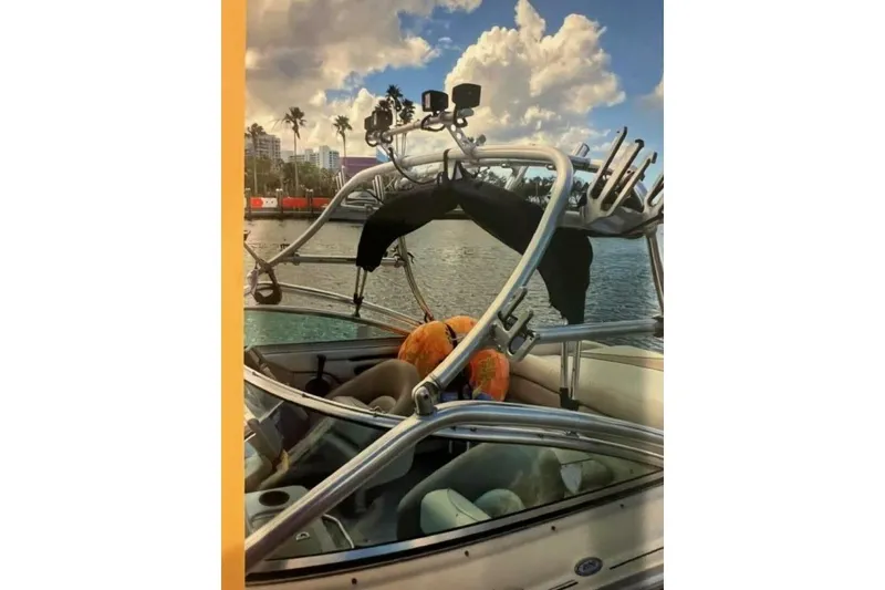 Slide: The Image of 2003 Sea Ray 220 Bow Rider on water, featuring wakeboard tower and scenic backdrop. - 29