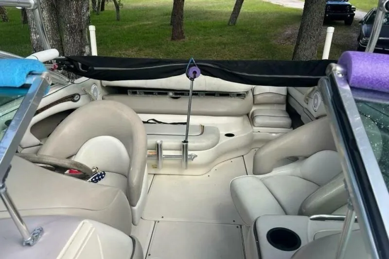 Slide: The Image of 2003 Sea Ray 220 Bow Rider interior with beige seating and steering wheel. - 5