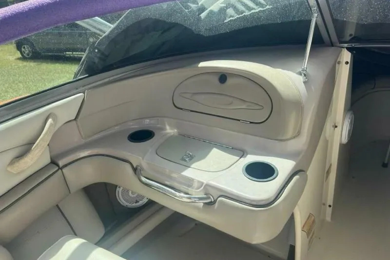 Slide: The Image of 2003 Sea Ray 220 Bow Rider interior with cup holders and storage compartment. - 7