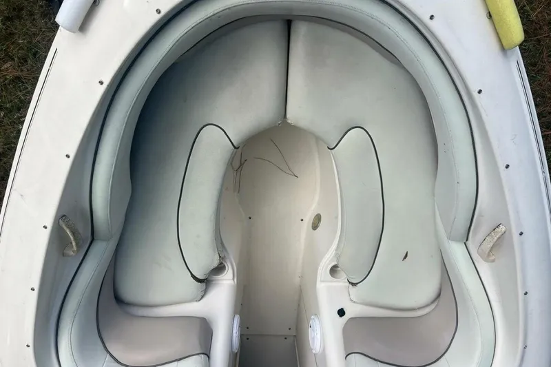 Slide: The Image of 2003 Sea Ray 220 Bow Rider boat interior with white cushioned seating. - 9