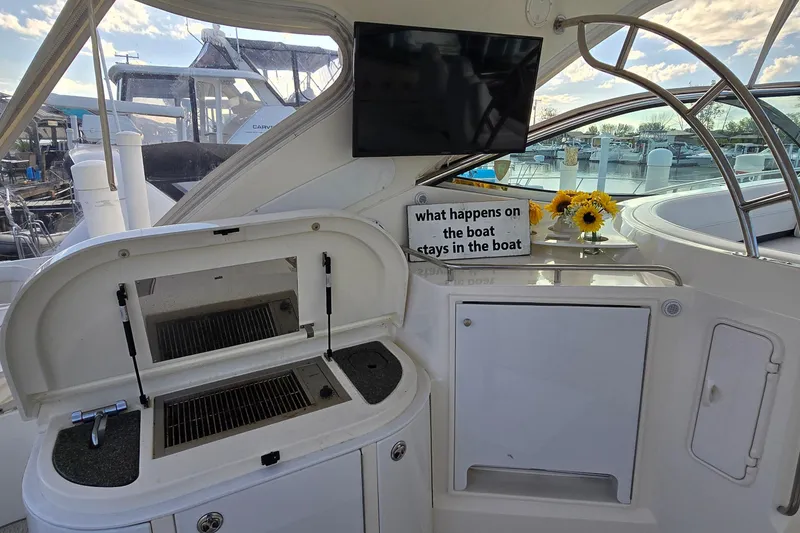 Slide: The Image of 2005 Cruisers Yachts 500 Express helm with navigation instruments and controls, docked at marina. - 13