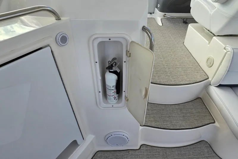 Slide: The Image of 2005 Cruisers Yachts 500 Express interior with white seating and helm, dockside view. - 15