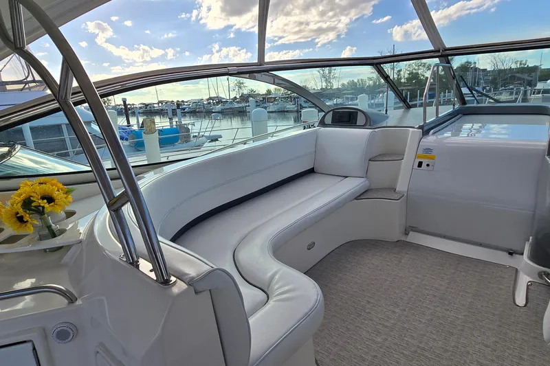 Slide: The Image of 2005 Cruisers Yachts 500 Express interior with seating, cabinets, and a TV under a clear sky. - 18