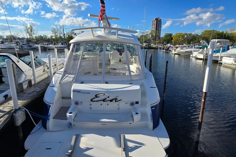 The Image of 2005 Cruisers Yachts 500 Express docked at marina under clear blue sky. - 2