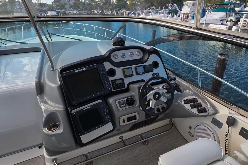 Slide: The Image of 2005 Cruisers Yachts 500 Express interior with white seating and marina view. - 20