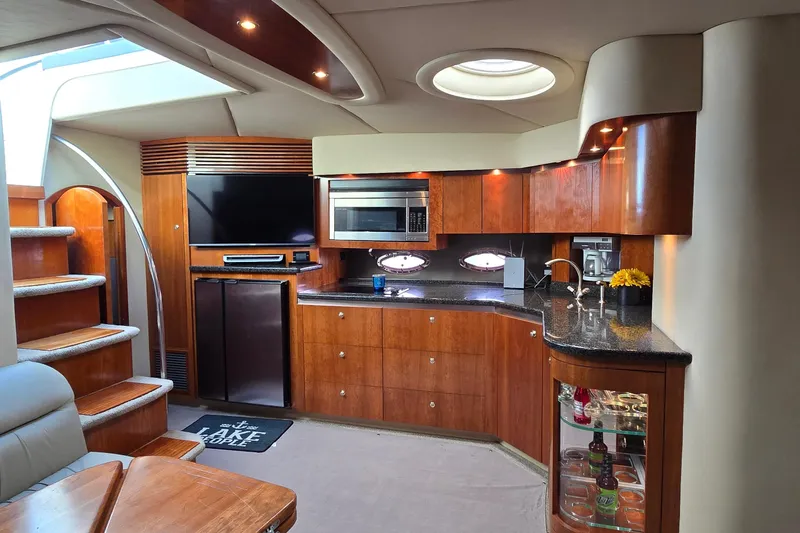 Slide: The Image of 2005 Cruisers Yachts 500 Express interior with seating and helm, docked under clear skies. - 24