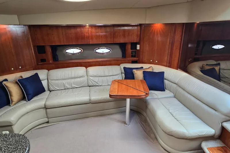 Slide: The Image of 2005 Cruisers Yachts 500 Express cabin with wood paneling and cozy bed. - 29