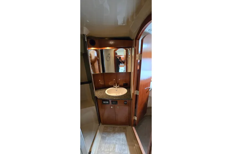 Slide: The Image of Interior of 2005 Cruisers Yachts 500 Express, featuring wood cabinetry and cozy seating area. - 34