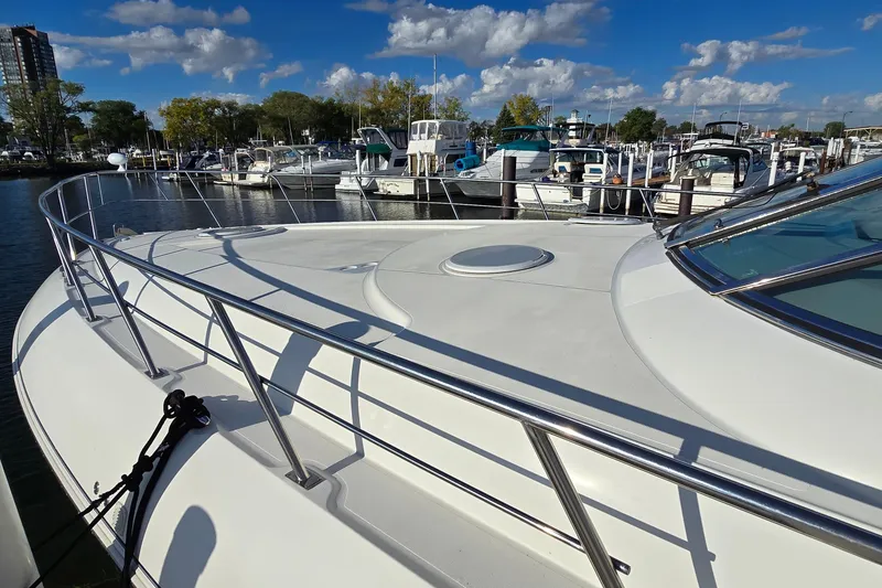 Slide: The Image of 2005 Cruisers Yachts 500 Express on calm water, sunny day, marina view. - 5