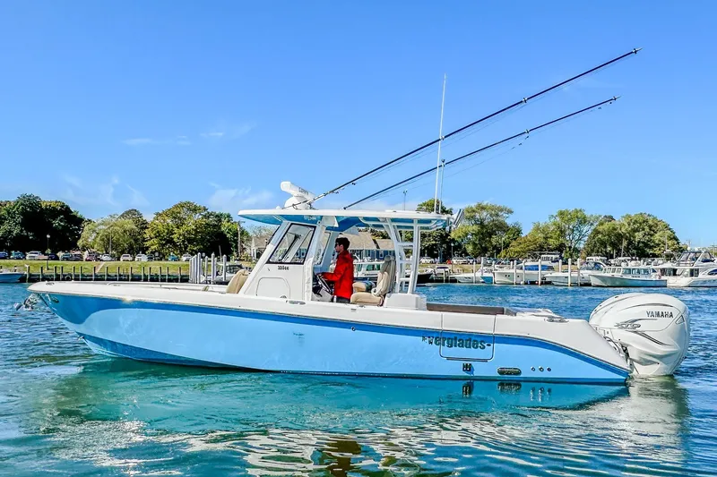 Slide: The Image of 2023 Everglades 335 Center Console boat on water, clear sky, scenic background. - 15