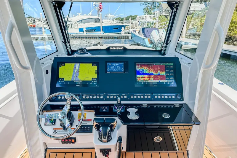 Slide: The Image of 2023 Everglades 335 Center Console helm with advanced navigation displays and controls. - 23