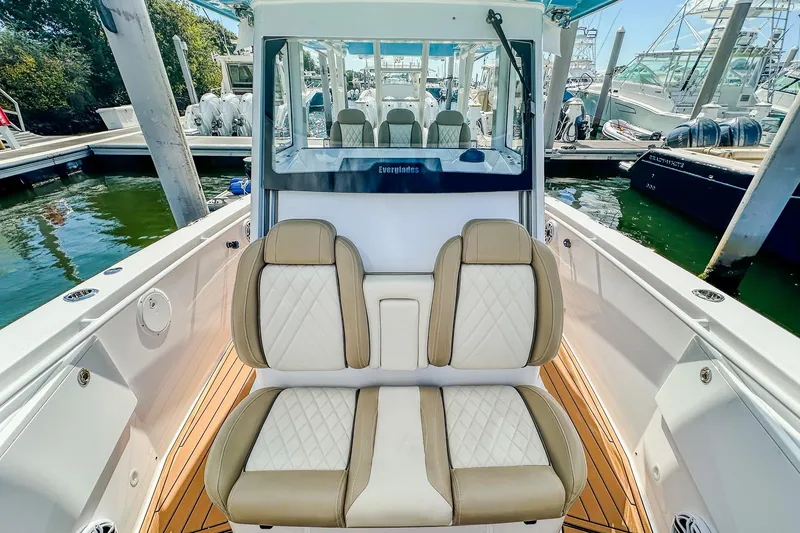 Slide: The Image of 2023 Everglades 335 Center Console boat interior with luxurious seating at marina. - 28