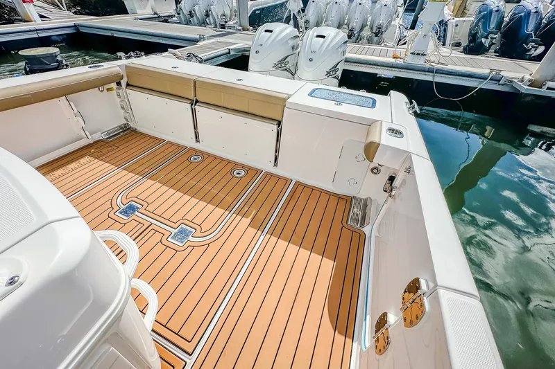 Slide: The Image of 2023 Everglades 335 Center Console boat with teak deck and triple outboard engines. - 29