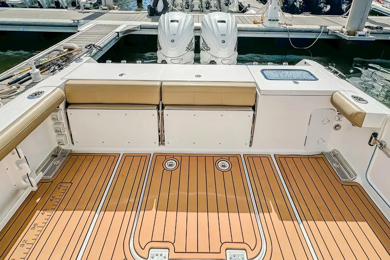 Slide: The Image of 2023 Everglades 335 Center Console boat interior with teak flooring and cushioned seating. - 31