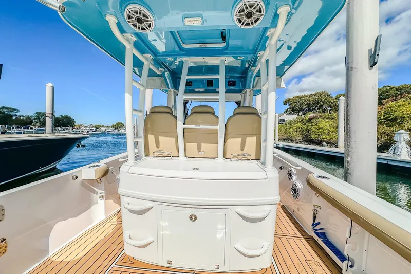Slide: The Image of 2023 Everglades 335 Center Console boat interior with seating and blue canopy. - 33