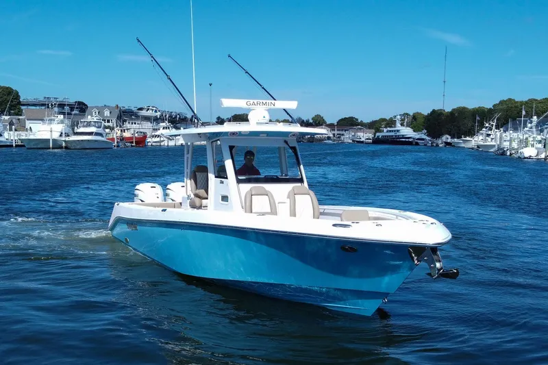 Slide: The Image of 2023 Everglades 335 Center Console boat cruising in a marina under clear blue skies. - 5