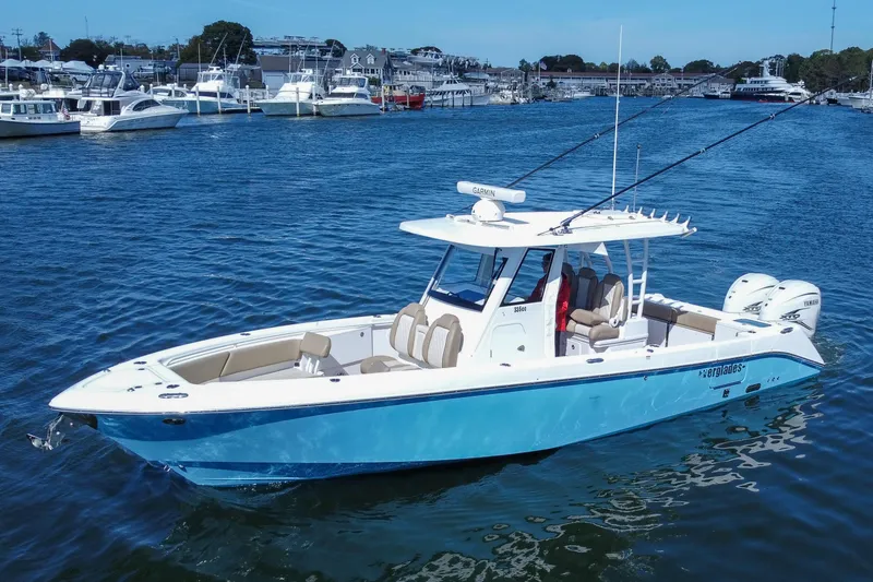 Slide: The Image of 2023 Everglades 335 Center Console boat cruising in a marina with multiple yachts. - 9
