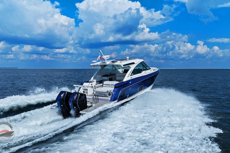 Slide: The Image of 2025 Formula 380 Super Sport Crossover OB cruising on open water under a blue sky. - 10