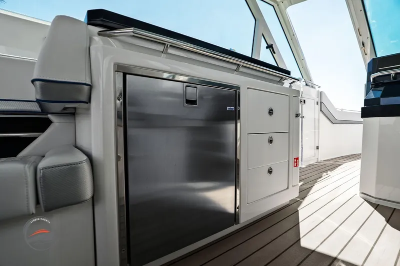 Slide: The Image of 2025 Formula 380 Super Sport Crossover OB interior with sleek cabinetry and stainless steel fridge. - 31