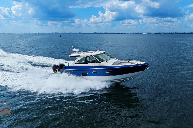 Slide: The Image of 2025 Formula 380 Super Sport Crossover OB cruising on open water under a blue sky. - 6