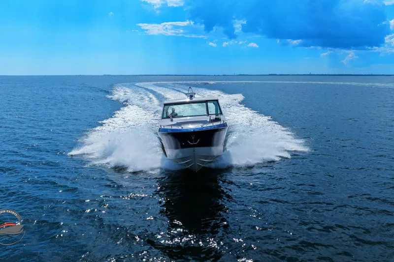 Slide: The Image of 2025 Formula 380 Super Sport Crossover OB speeding on open water under a clear blue sky. - 60