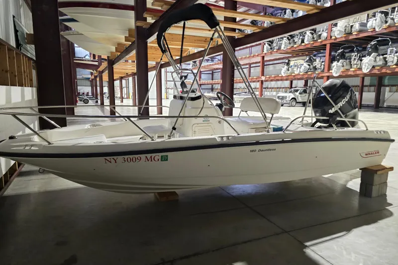 Slide: The Image of 2008 Boston Whaler 180 Dauntless boat in storage, featuring a Mercury outboard engine. - 9