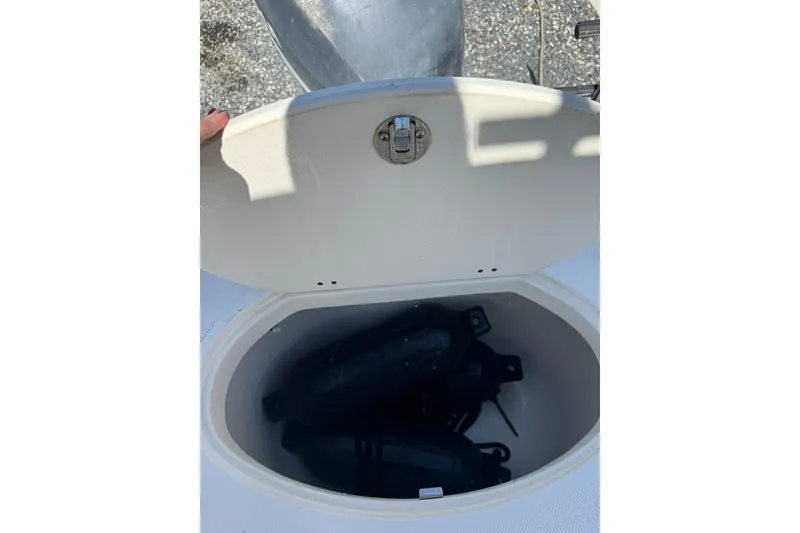 Slide: The Image of Open storage compartment on 2004 Hydra-Sports Lightning 202 DC boat, containing black fenders. - 14