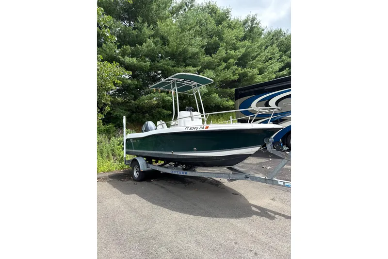 The Image of 2005 Seaswirl Striper 1851 Center Console boat on trailer, parked outdoors. - 2